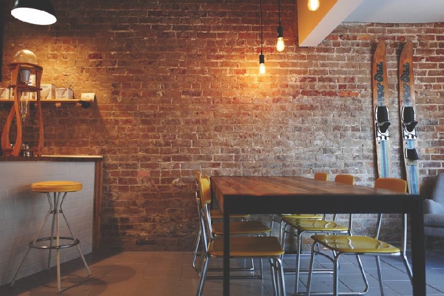 Restaurant in front of a brick wall.